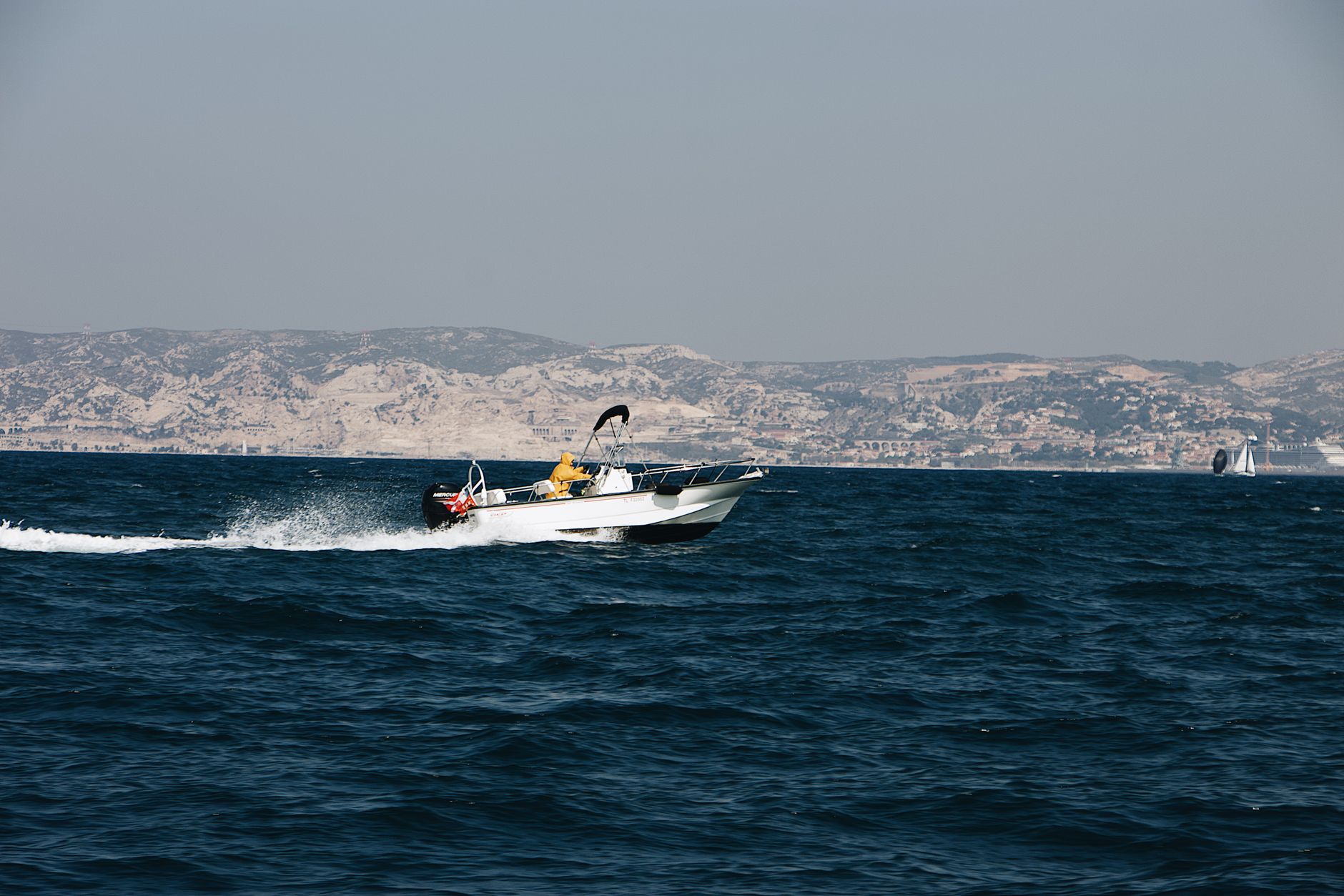 A high-speed white boat racing through the waves on the Black Sea near the Batumi coastline