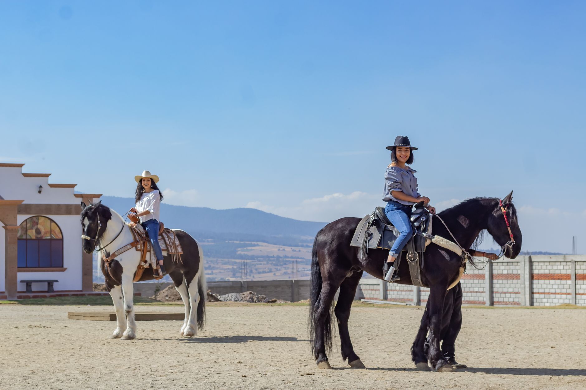 A group of riders follows a mountain path in a picturesque Caucasus valley under the sun.