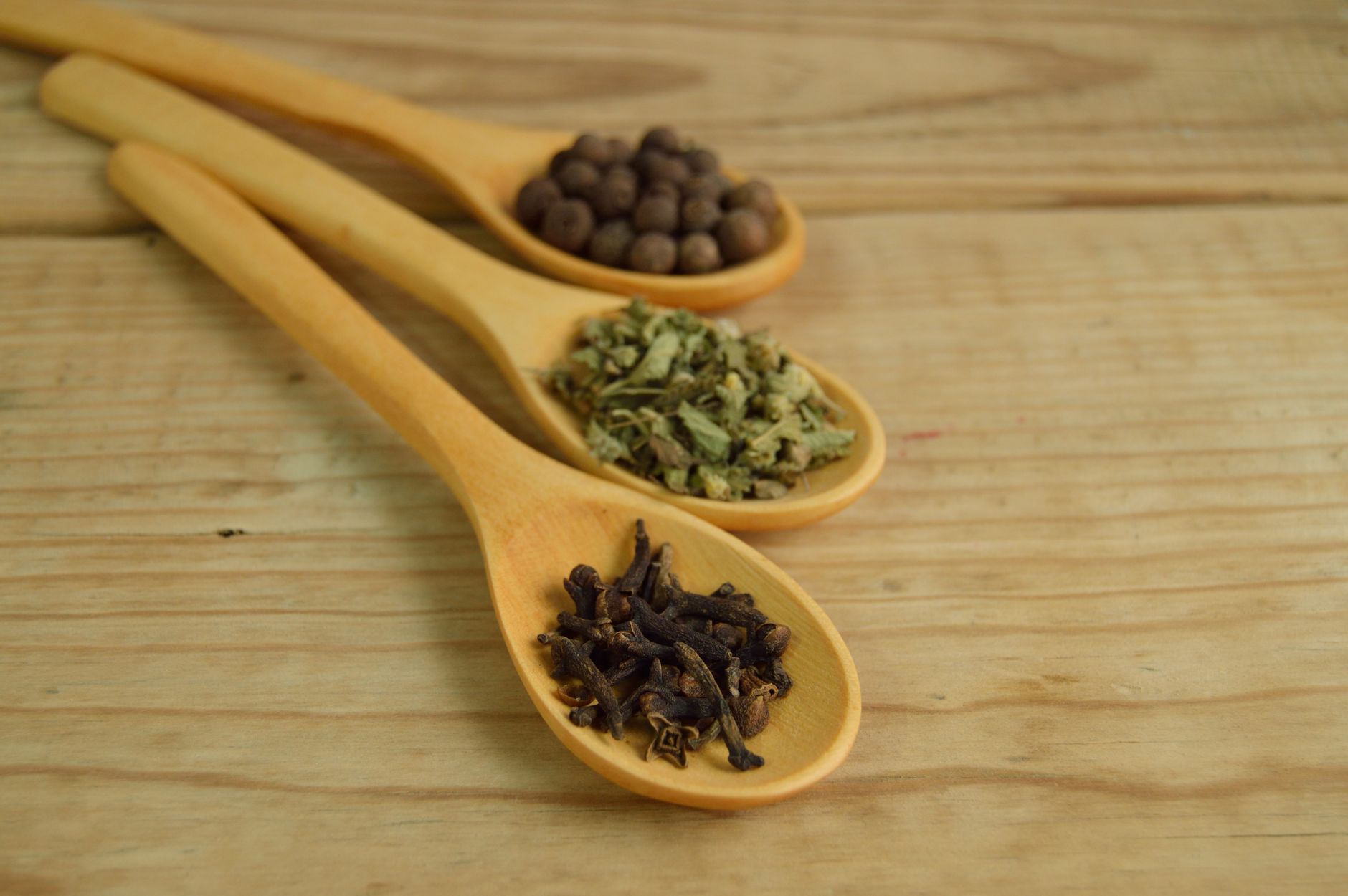 Various Georgian spices and walnut pkhali in ceramic dishes on a wooden table