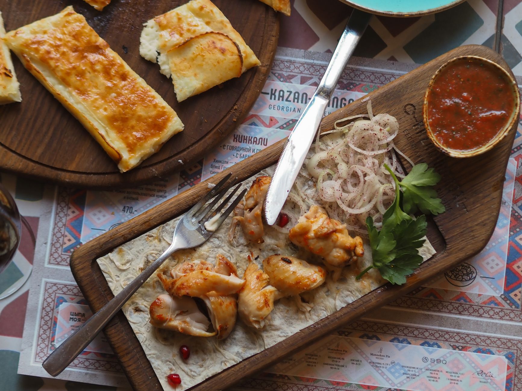 A traditional Georgian feast table in Kakheti, set against a vineyard background