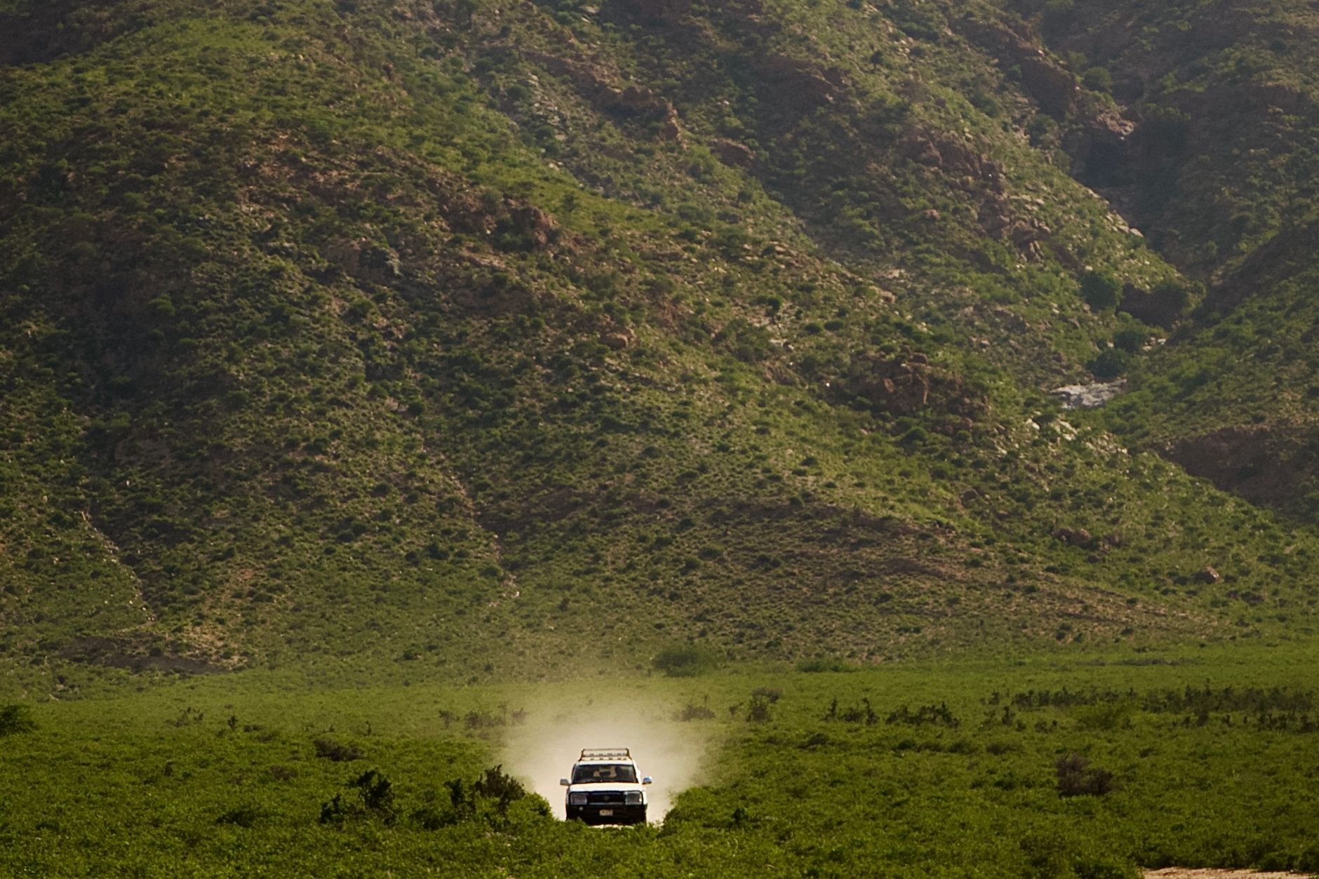 A white 4x4 vehicle driving on a narrow, rocky mountain road in the Egrisi Range