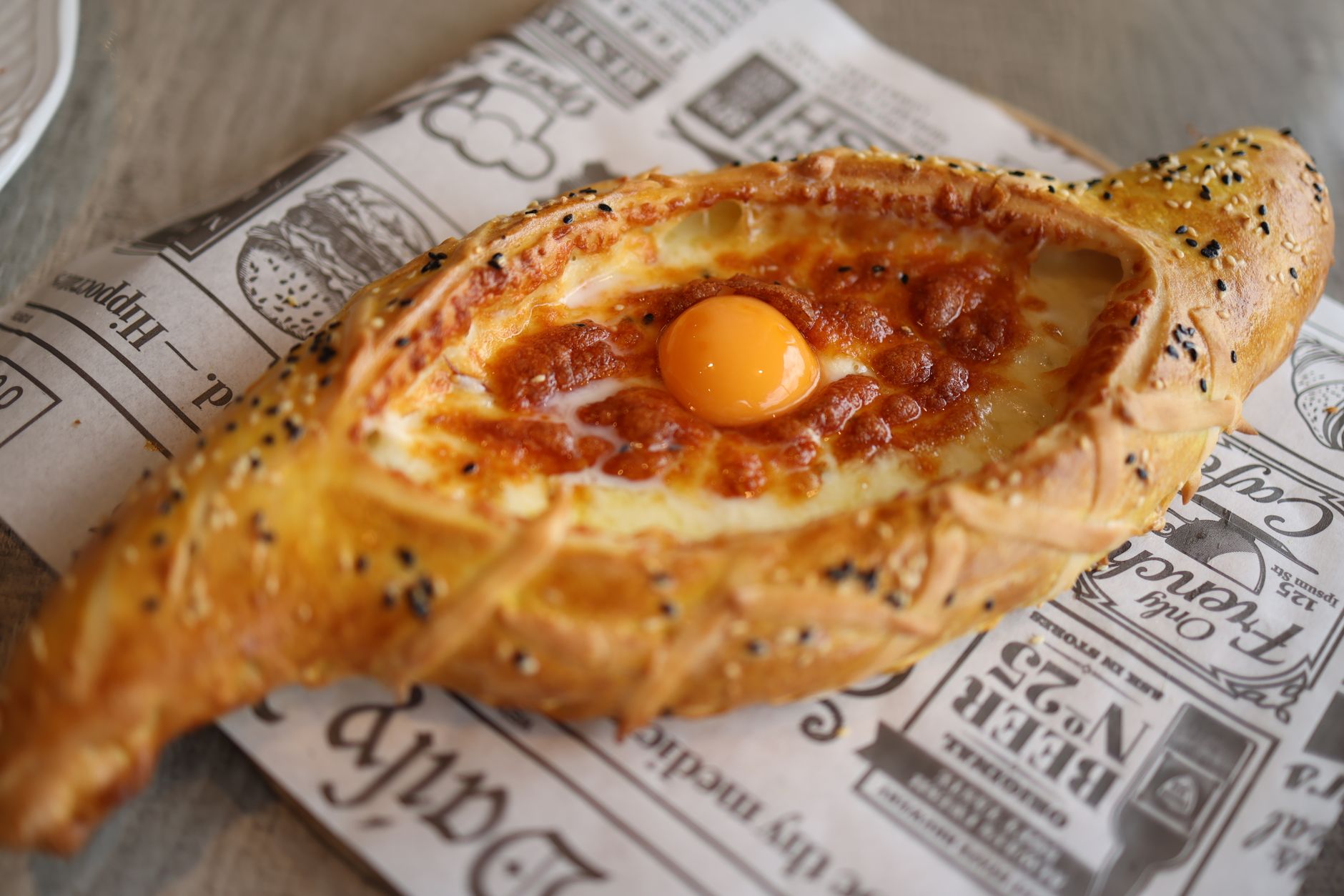 Warm Adjarian and Imeretian khachapuri on a wooden table in a Kakhetian restaurant
