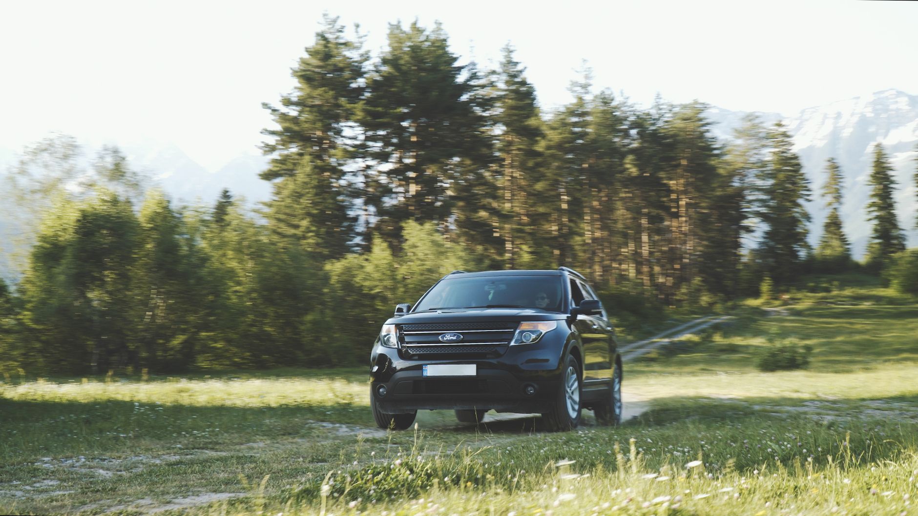 თეთრი 4x4 ყველგანმავალი ავტომობილი გაჩერებული სვანეთის მთების ფონზე მზის ჩასვლისას