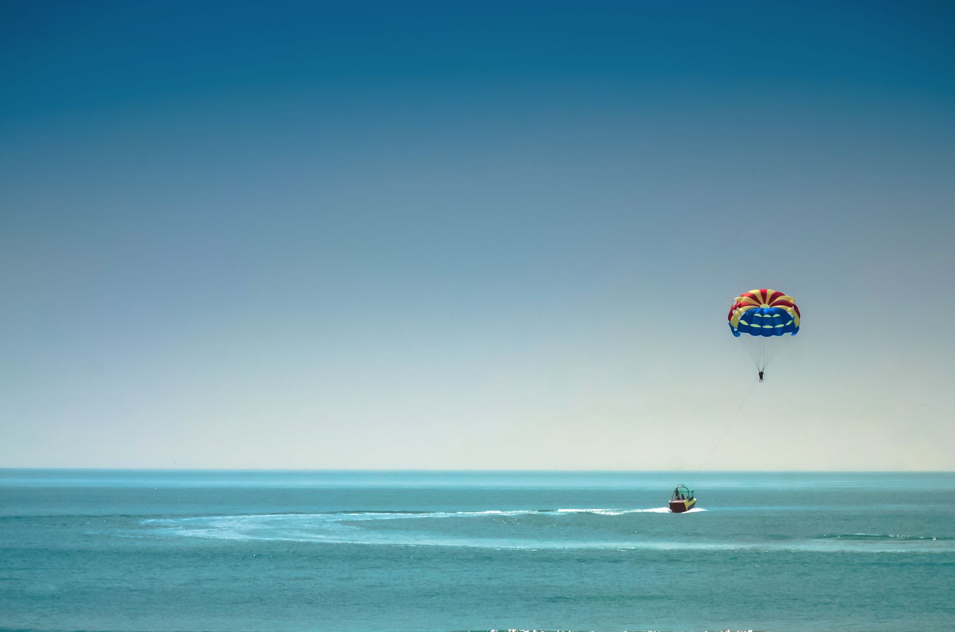 A parachute flying over the sea against a blue sky near the Batumi coastline