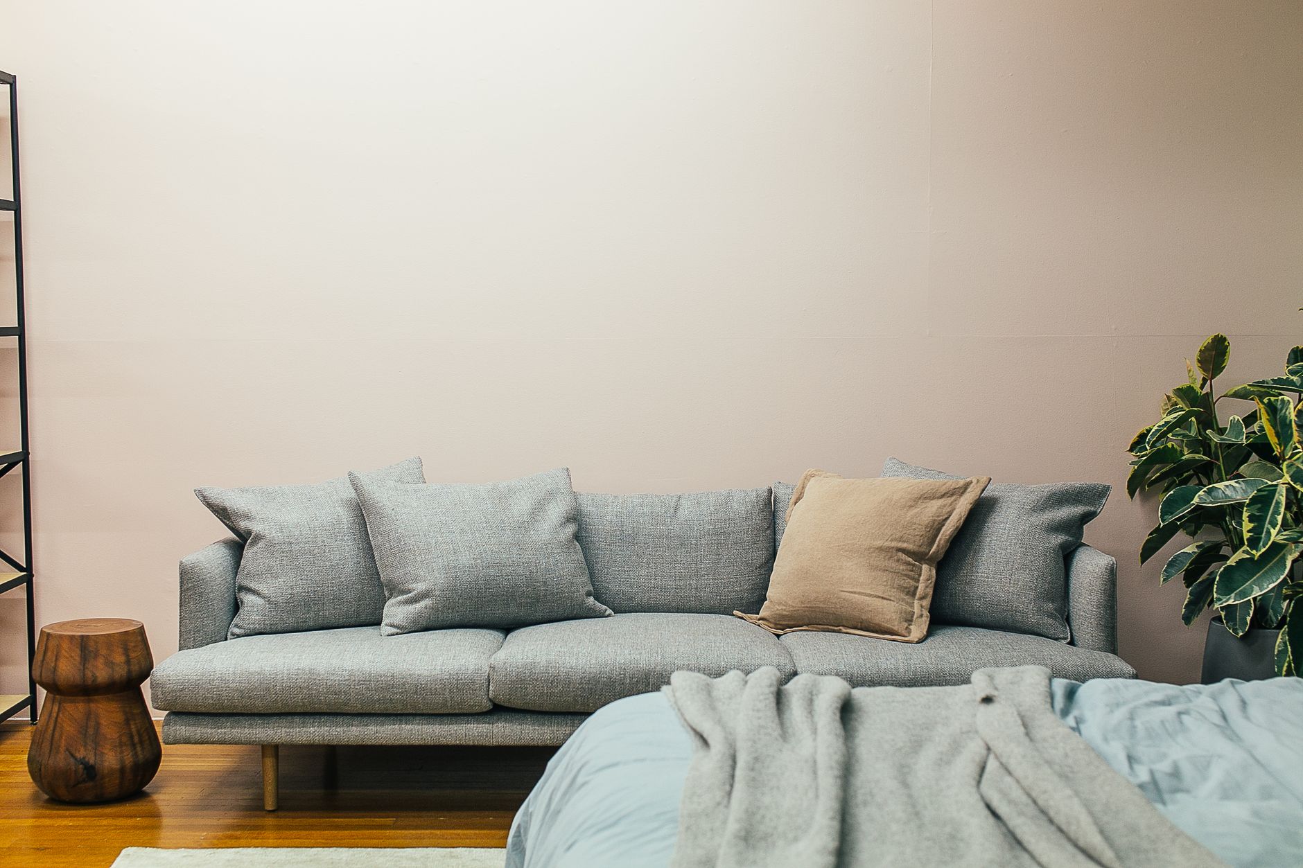 A modern gray sofa in the center of a living room that harmoniously blends with the environment