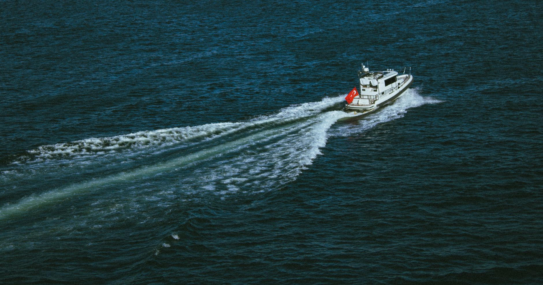 A high-speed boat cutting through Black Sea waves near the Batumi coastline on a sunny day