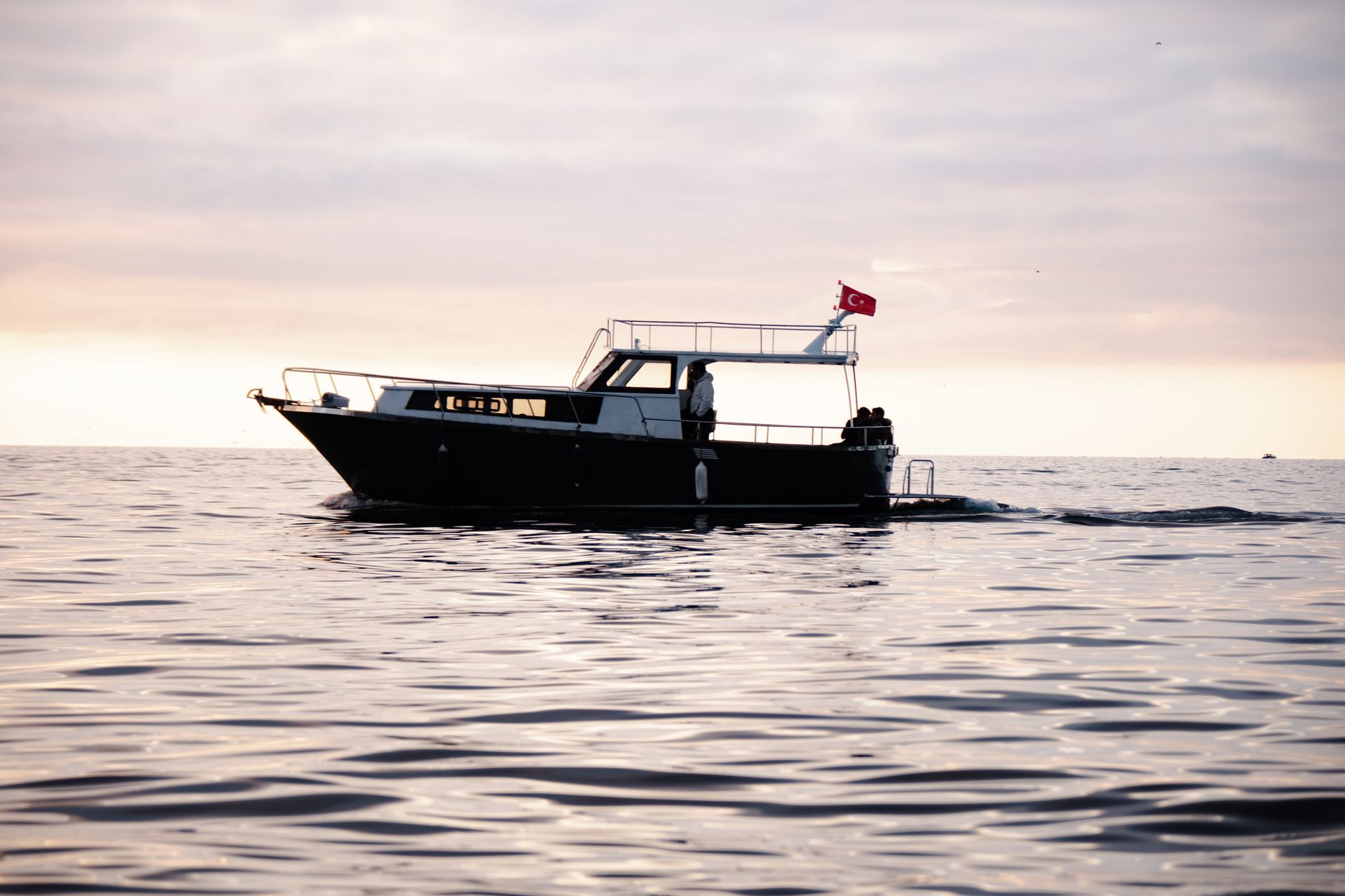 A private yacht at the Batumi Marina during sunset with a small group relaxing on deck
