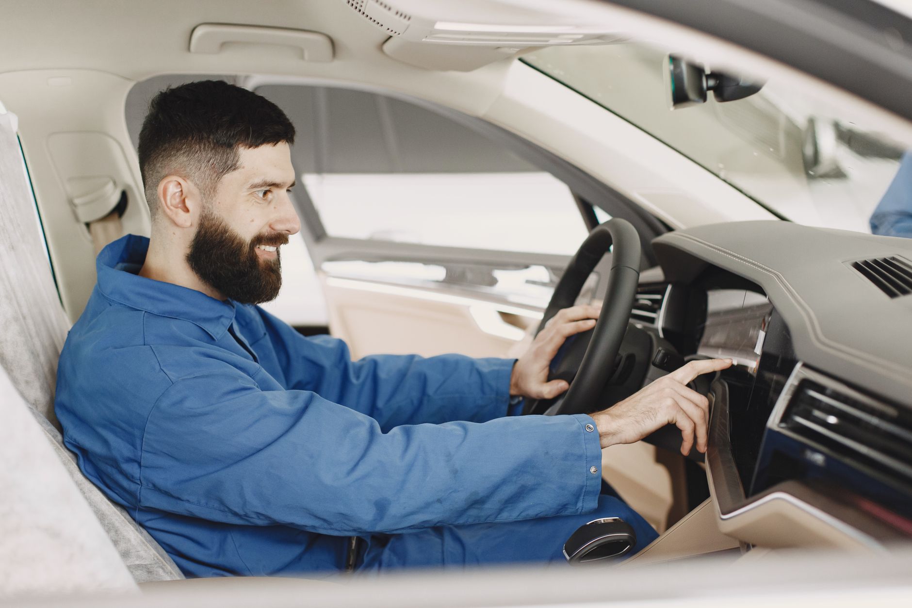 A male traveler inspecting the condition of a white premium SUV at an airport parking lot during sunset.