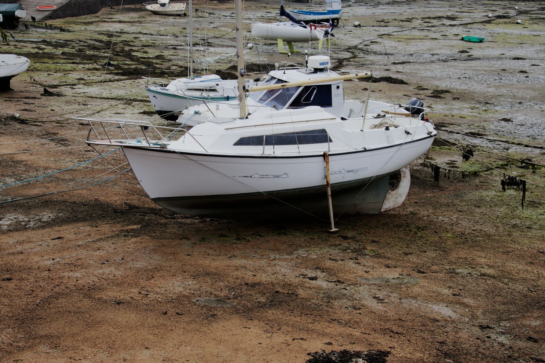 A white yacht being cleaned at the Batumi Marina, with the deck illuminated by sunlight.