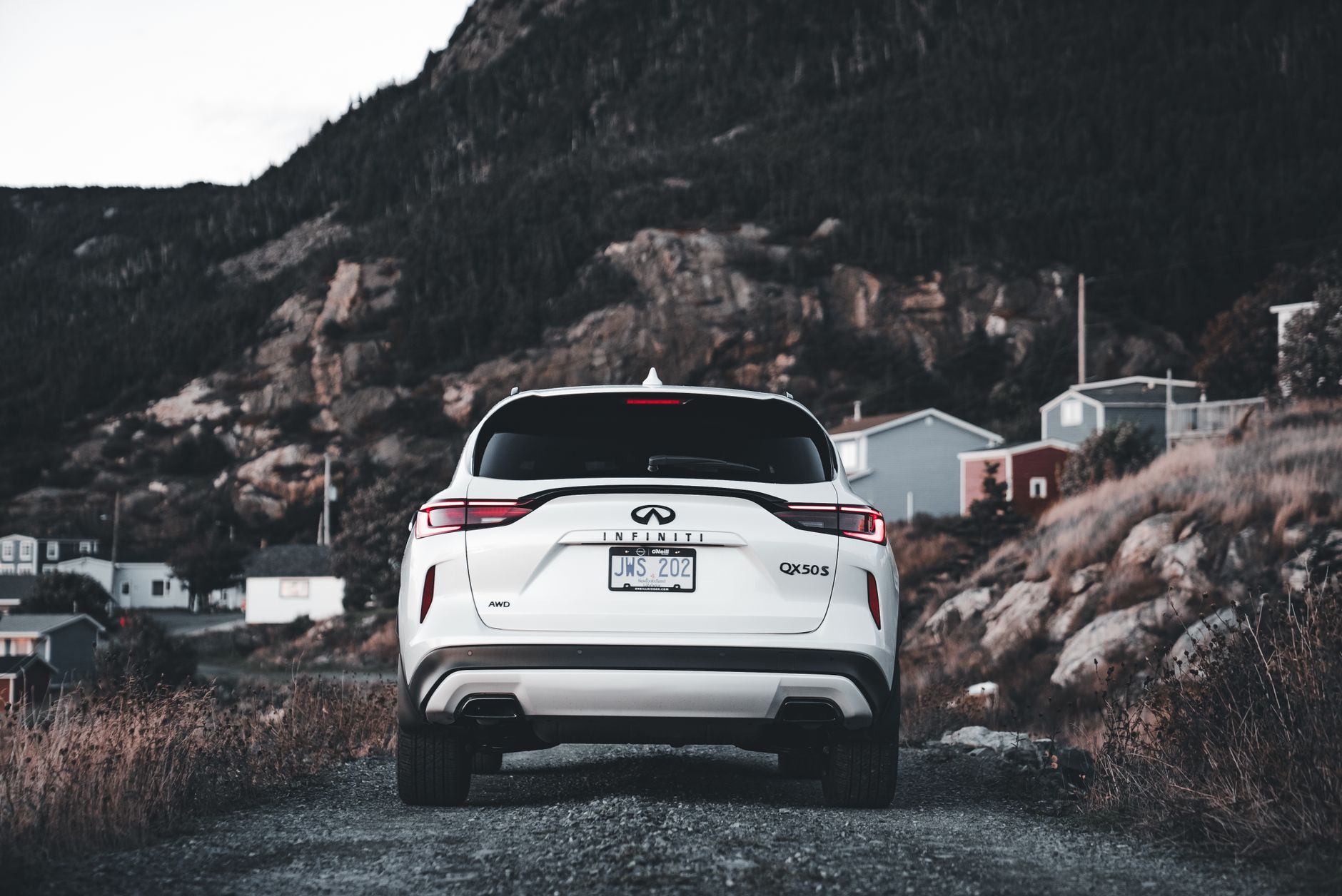 A white SUV driving on a Georgian mountain road against a backdrop of beautiful green landscapes.