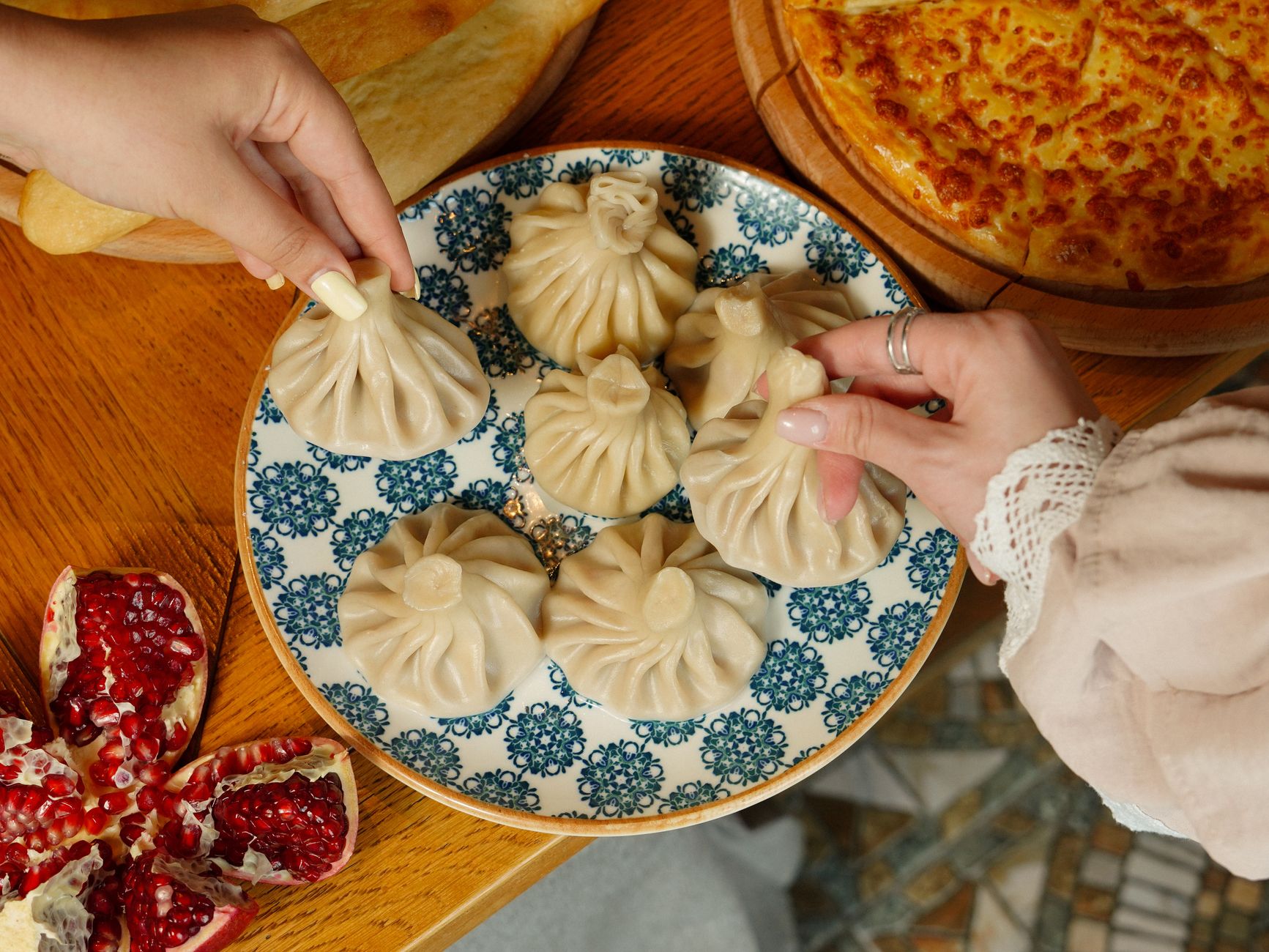 Una vibrante selección de platos tradicionales georgianos, incluyendo khachapuri y pkhali, servidos sobre una mesa de madera.